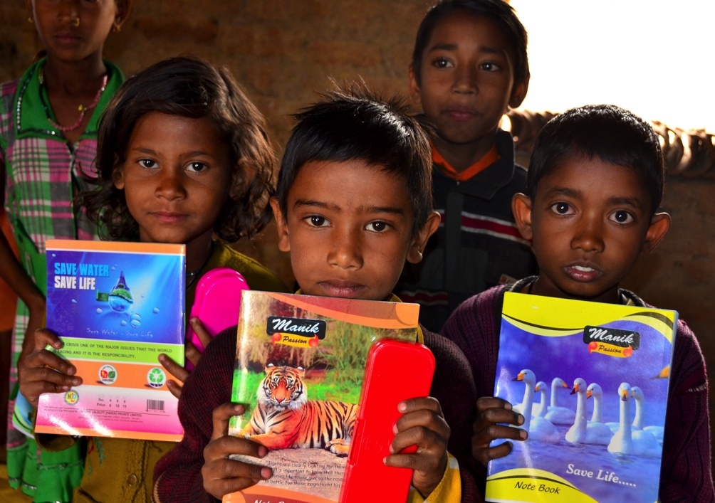 Village school children holding new notebooks and learning materials