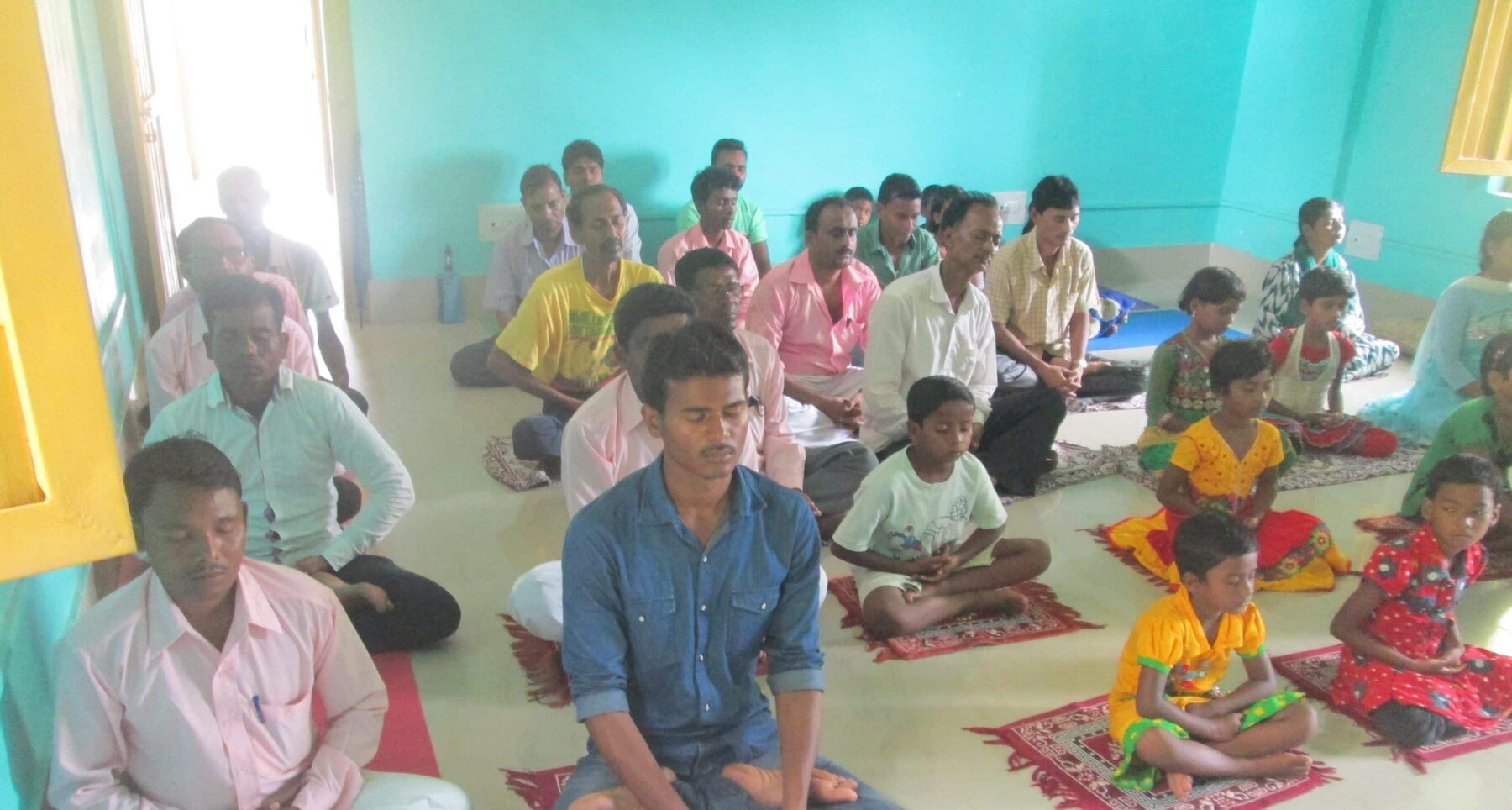 Group meditation at the centre Adults and children participating in group meditation at the treatment centre